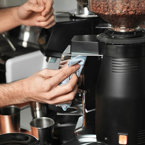 Person cleaning a coffee grinder