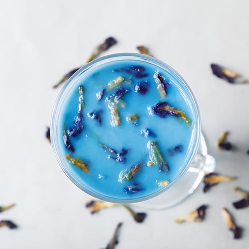 vibrant blue moon Thai tea garnished with butterfly pea tea flowers