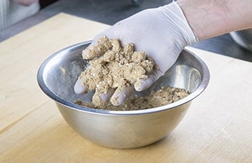 In a mixing bowl, combine the crumb crust ingredients and hand mix.