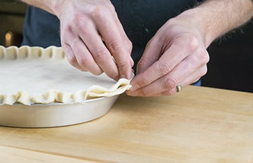 Crimp the bottom and top pie crust edges together.
