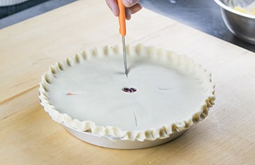 Use a knife to cut a small hole out of the center of the pie and make four diagonal slits around the hole to allow steam to vent. Bake according to your recipe's instructions.