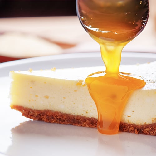 Hot honey poured over white cheesecake.