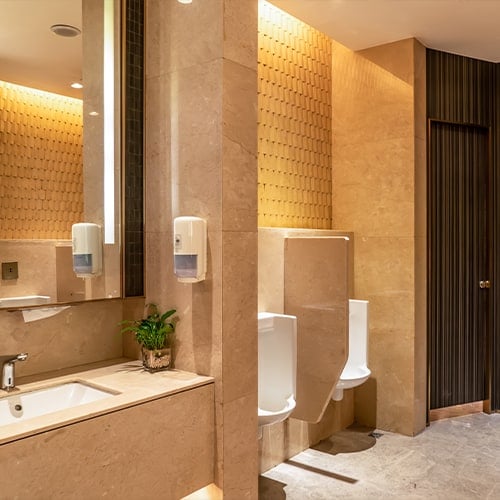 restroom with marble tiled walls elegant lighting and a large mirror