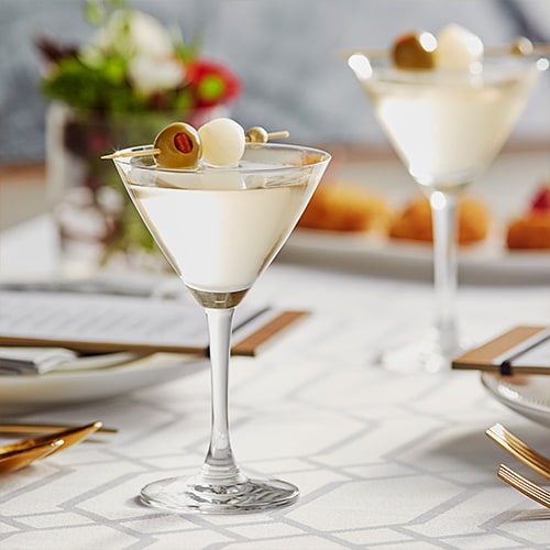 small martini glasses garnished with olives and onions
