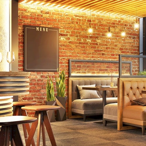 trendy restaurant interior with brick wall, cushioned seats, and modern decorations