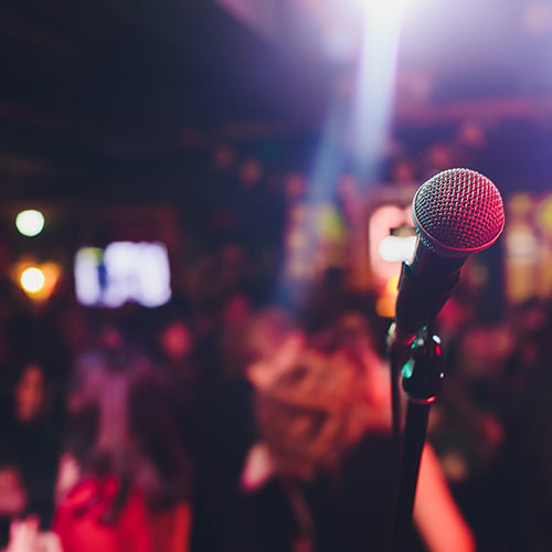 a microphone on a stage in front of tables of people eating