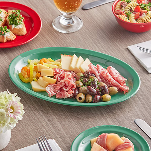 charcuterie board with green and red melamine dishes