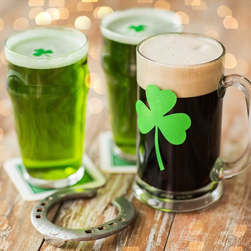 shamrock on glasses of beer and horseshoe on wooden table