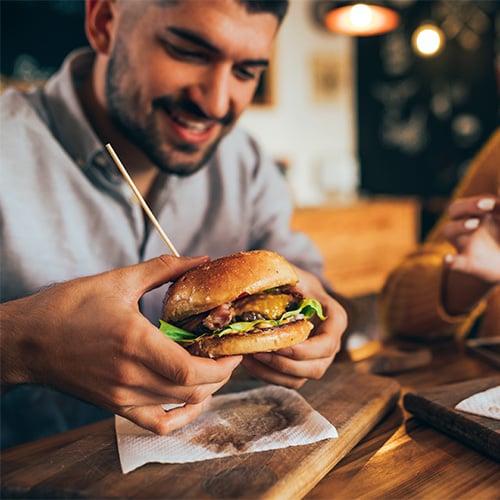 Person eating burger at the bar