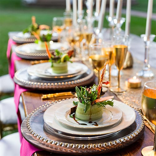 Elegant table setting using clear charger plates with gold rims