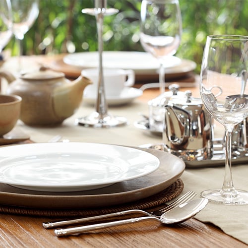 Earth toned dinner table setting using beige charger plates