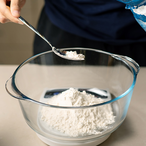 Measuring flour on a kitchen scale while baking