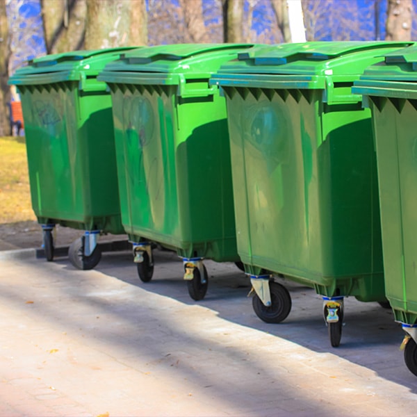 outside view of four green trash dumpsters
