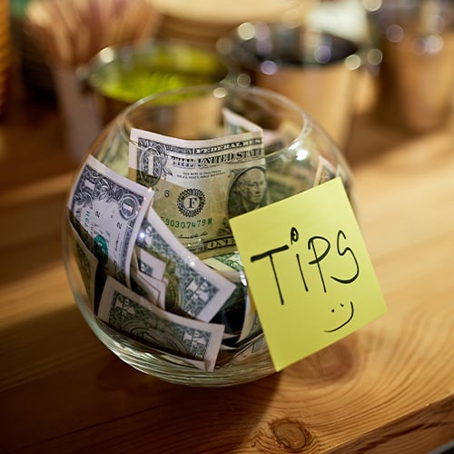 Tip jar with a smiley face sticky note 