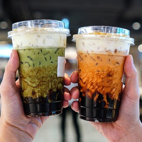 two cups of bubble tea topped with cheese cream