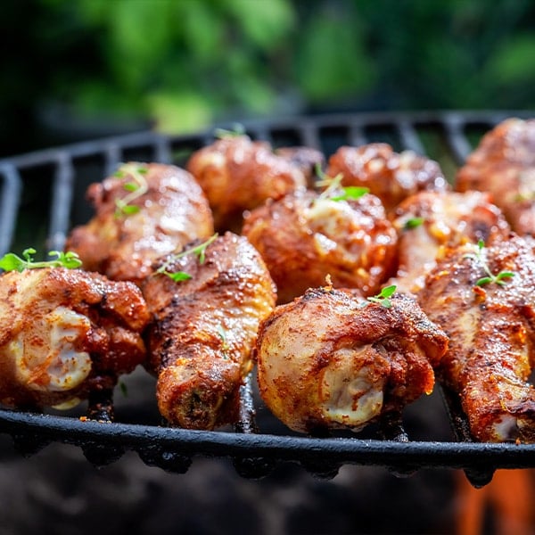 hot grilled chicken leg marinated with honey and spices on a grill