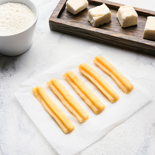 Uncooked churros and ingredients on table