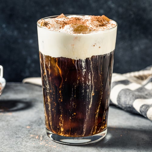 Black coffee with cold foam and cinnamon on top