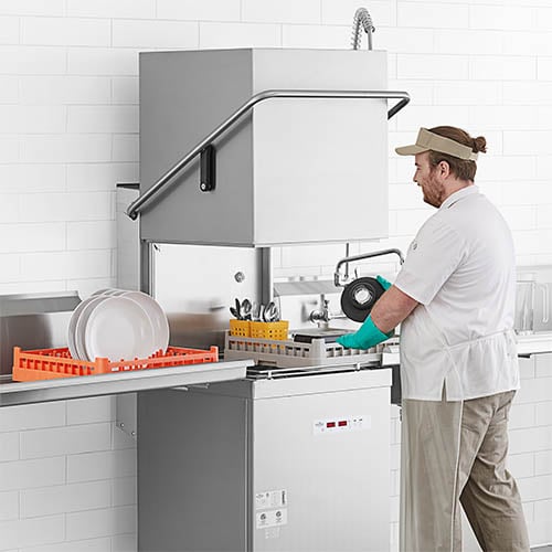 Man Loading single rack commercial dishwasher 