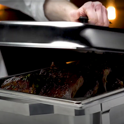 covering a chafer dish with its lid to keep food warm inside