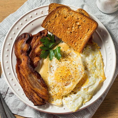 Over Easy Eggs served with crispy bacon and toast