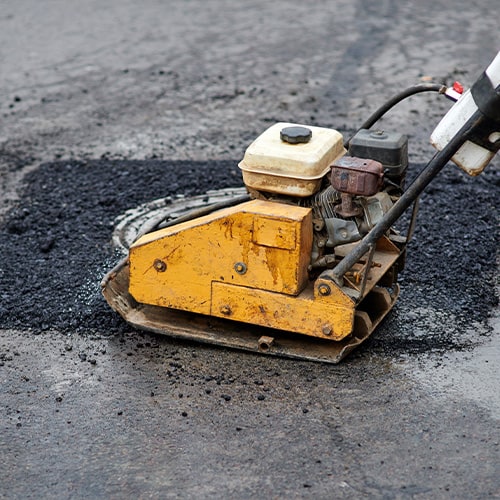 Pothole repair process using an asphalt tamping machine