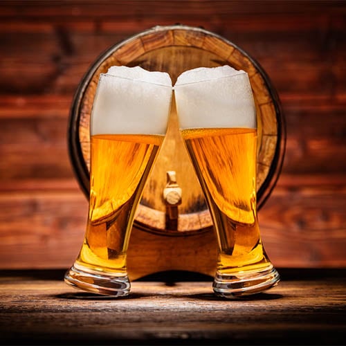 Glasses of lager with old wooden keg