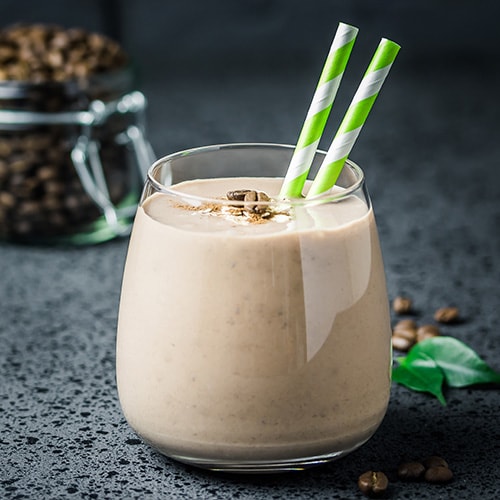 mocha breakfast smoothie and coffee beans in glass jar on dark concrete background