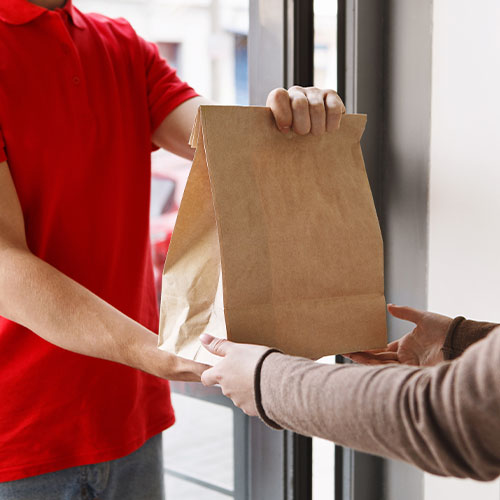 Delivery man handing bag to client