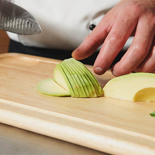 close up of person cutting an avocado