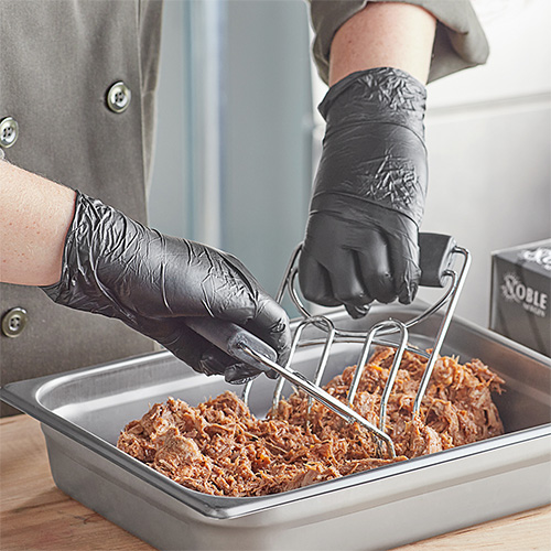 Hands with black disposable gloves shredding cooked pork