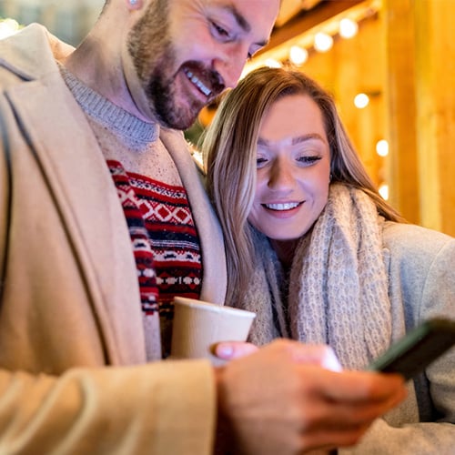 Couple looking down at smartphone