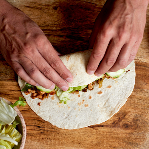 Person rolling a burrito