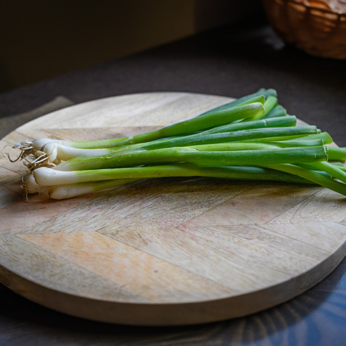 A bundle of green onions sitting on a circular table