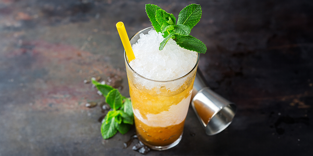 Top view of a peach ginger julep in a glass on a dark background