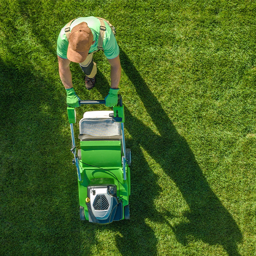Aerial photo of a man mowing the lawn with a push mower