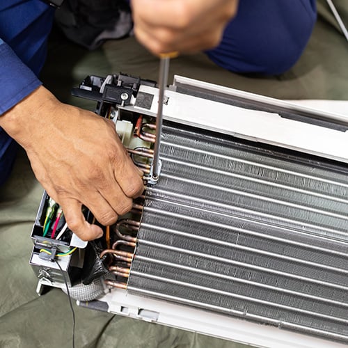 A technician repairing an air conditioner