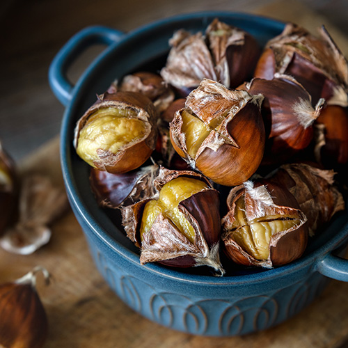 unpeeled roasted chestnuts close up on a table