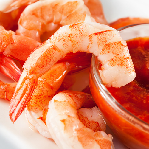 Shrimp dipped into cocktail sauce