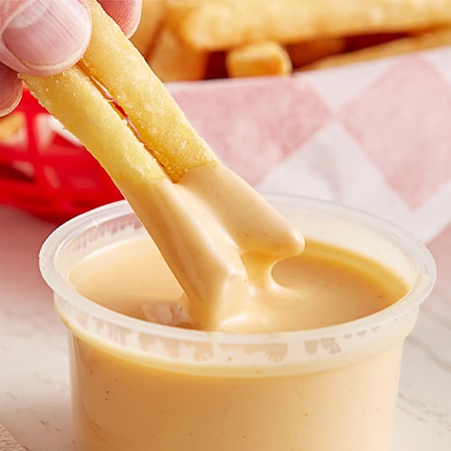 Fries dipping into sauce