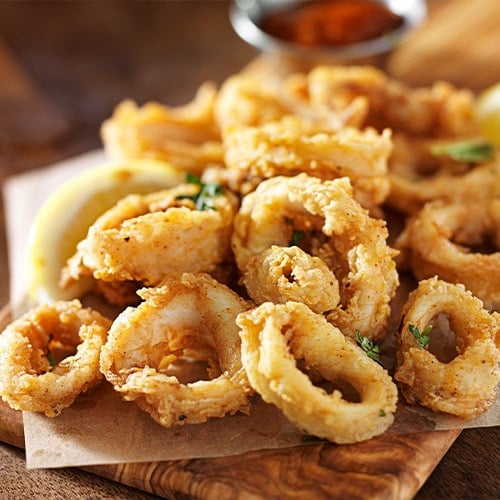fried calamari served on a wood board with marinara