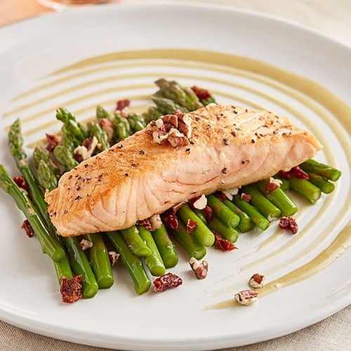 plated salmon filet with asparagus and walnuts