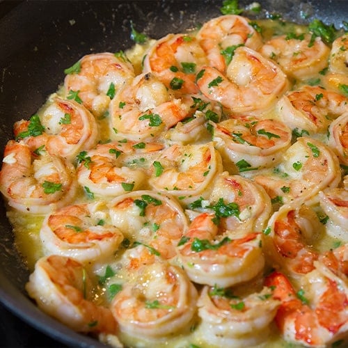 shrimp scampi cooking in a frying pan