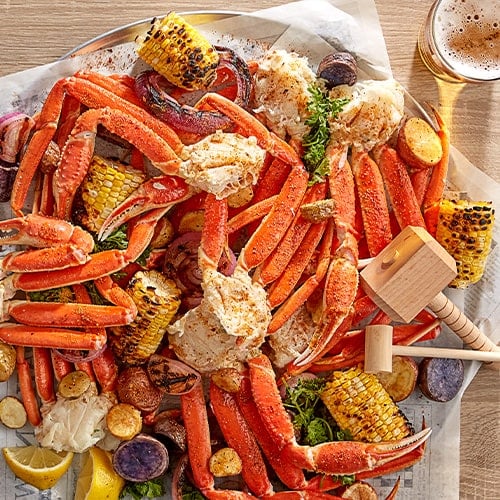 traditional seafood boil with crab legs corn potatoes on newspaper