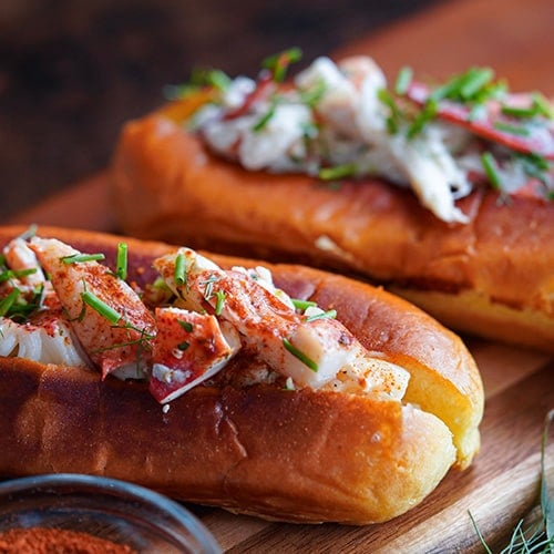 two lobster rolls on a serving board