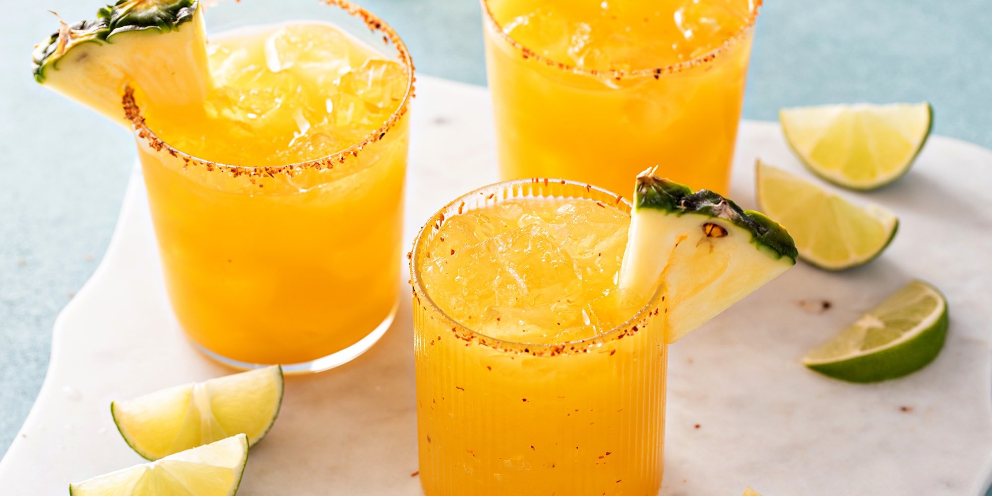 Top view of two habanero pineapple margaritas with ingredients and garnishes