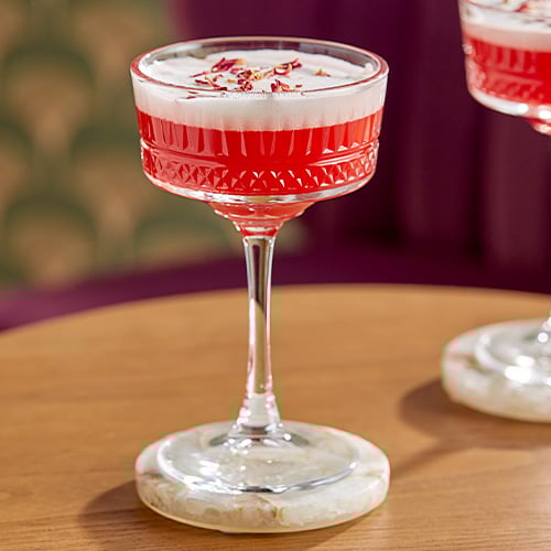 Beautiful vintage glassware holding a red drink