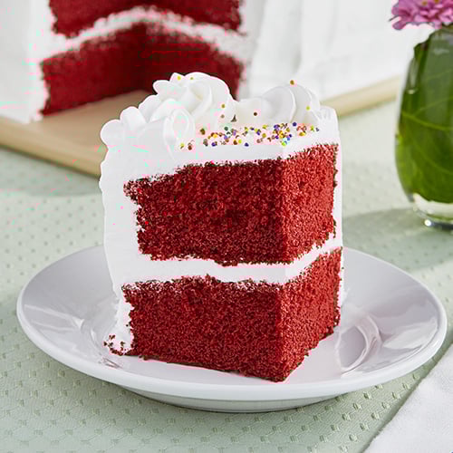 Red velvet cake with white frosting on a plate