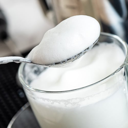 closeup of spoon with frothed milk