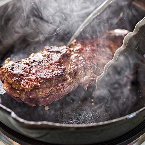 close up of steak in a cast iron pan